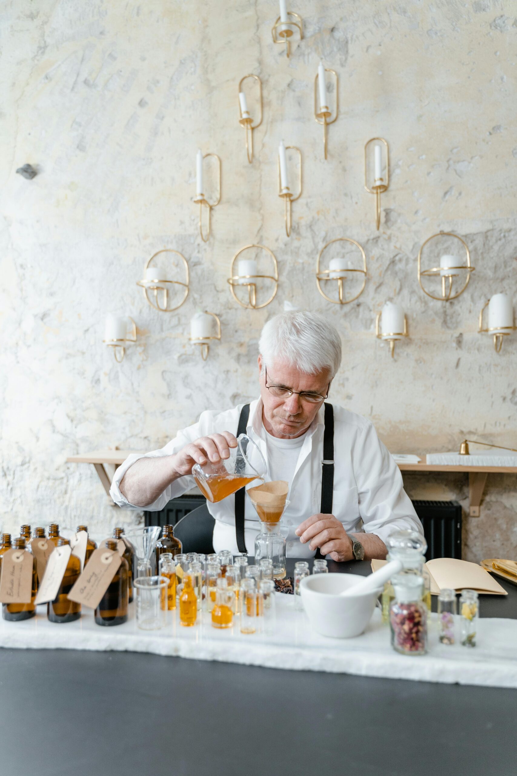 Man pouring different amounts of liquids, formulating a product.